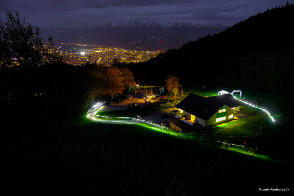 Le camp de base illuminé et les lumières de la vallée en 2025